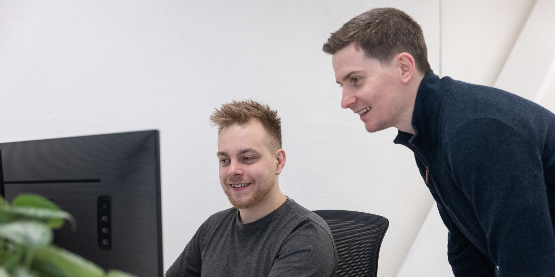 Utviklere Preben og Alex samhandler ved PC